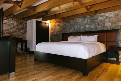 a bedroom with a large bed and a brick wall at Lofts du Vieux-Port by Gray Collection in Montréal