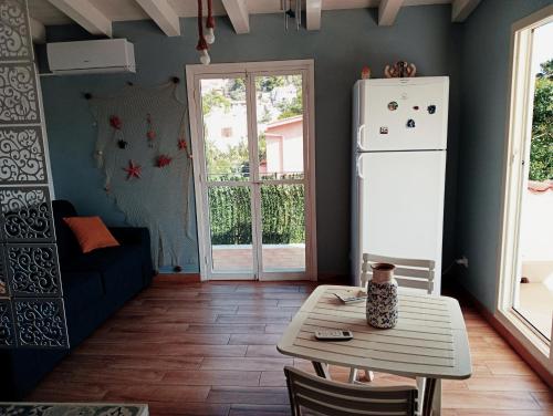a kitchen with a table and a white refrigerator at Da Carmen e Peppe in Santa Flavia