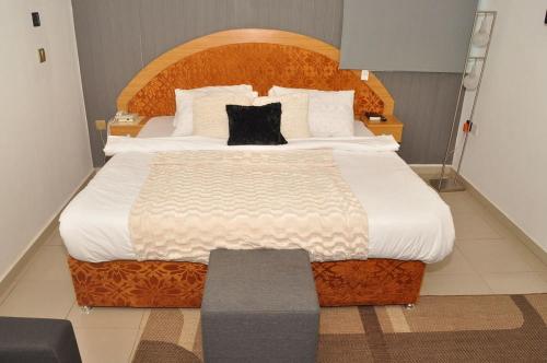 a bedroom with a large bed with a wooden headboard at Ne-yo hotel & rv lodges in Asaba