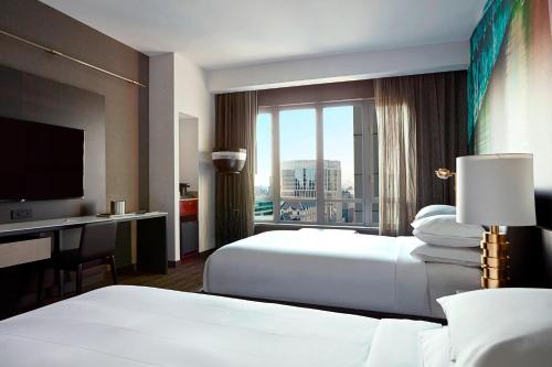 a hotel room with two beds and a desk and a television at New York Marriott at the Brooklyn Bridge in Brooklyn