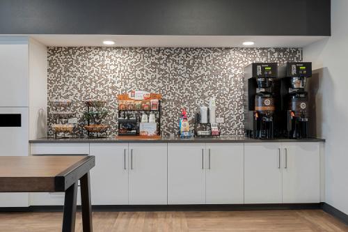 a coffee bar with white cabinets and a wallpaper at Extended Stay America Suites - Atlanta - McDonough in McDonough