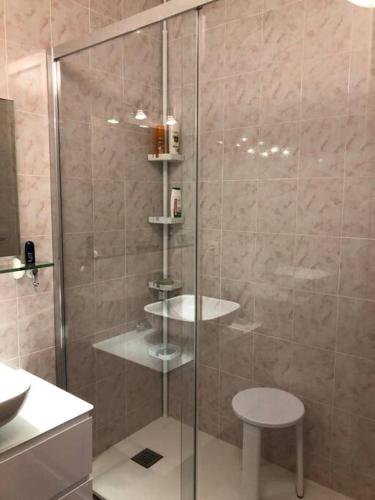 La salle de bains est pourvue d'une douche en verre avec un tabouret. dans l'établissement Quiet and cozy 1BR close to beach and all services, à Saint-Raphaël