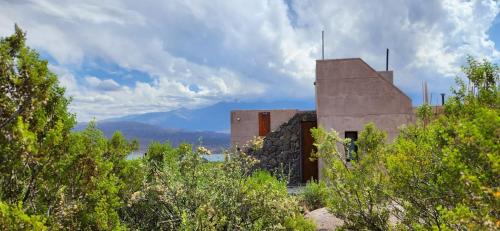 an old building sitting on top of a hill with trees at La Calma Ecolodge in Las Heras