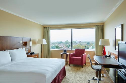 ein Hotelzimmer mit einem Bett, einem Schreibtisch und einem Fenster in der Unterkunft London Twickenham Stadium Hotel, a member of Radisson Individuals in Twickenham