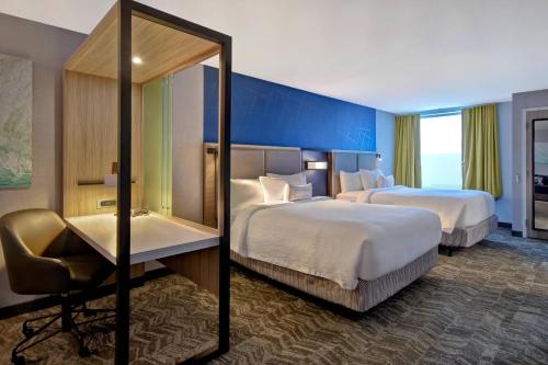 um quarto de hotel com duas camas e um espelho em SpringHill Suites Holland em Holland