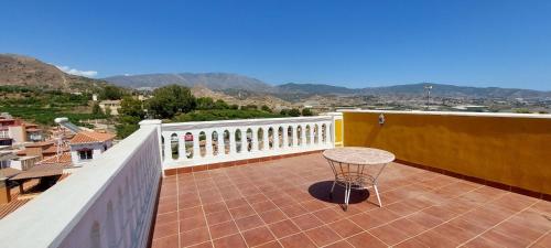 a table on a balcony with a view of the mountains at Villa Granada Motril in Motril
