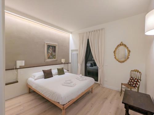 Schlafzimmer mit einem Bett, einem Schreibtisch und einem Spiegel in der Unterkunft La Piccola Corte - Sweet Dreams in Florence in Florenz