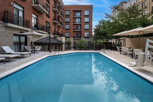una grande piscina blu con sedie e tavoli di Courtyard by Marriott Savannah Downtown - Historic District a Savannah