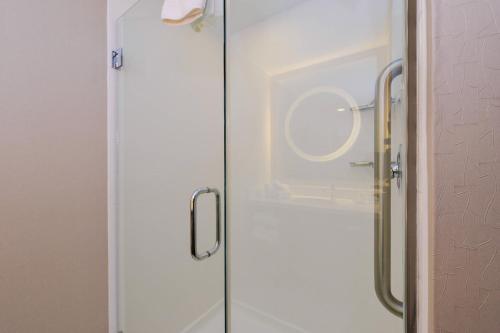 a glass shower door with a mirror in a bathroom at SpringHill Suites Durham Chapel Hill in Durham
