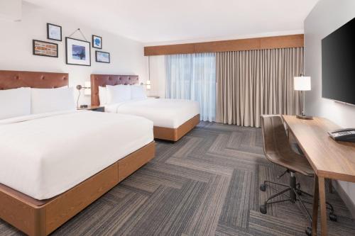 ein Hotelzimmer mit 2 Betten und einem Schreibtisch in der Unterkunft Four Points by Sheraton Spartanburg in Spartanburg