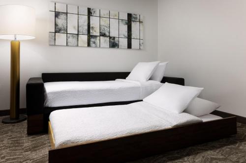 two twin beds in a room with a lamp at SpringHill Suites Fresno in Fresno
