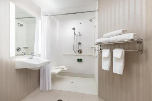 a white bathroom with a sink and a shower at SpringHill Suites Fresno in Fresno