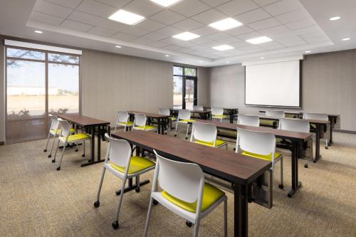 a conference room with tables and chairs and a whiteboard at SpringHill Suites Fresno in Fresno