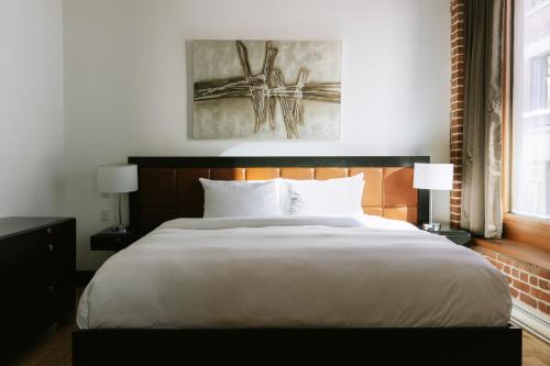 a bedroom with a large white bed and two lamps at Lofts du Vieux-Port by Gray Collection in Montréal