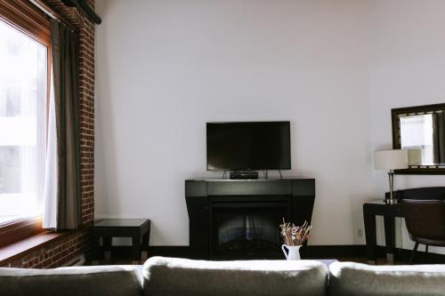 a living room with a couch and a fireplace at Lofts du Vieux-Port by Gray Collection in Montréal