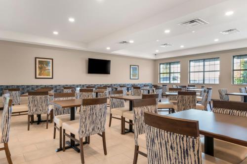 a dining room with tables and chairs and a flat screen tv at Pestana Orlando Suites - Lake Buena Vista in Orlando