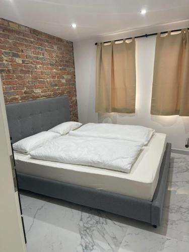 Bett in einem Zimmer mit Ziegelwand in der Unterkunft PrimeBnb LuxusApartment in Wetzlar