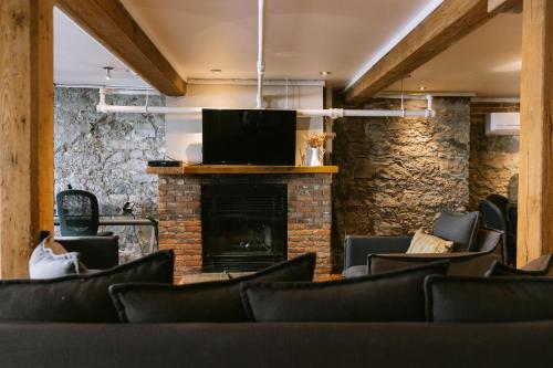 Habitación con sillas, chimenea y TV. en Lofts du Vieux-Port by Gray Collection, en Montreal