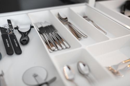 a white drawer with utensils on a table at Koje Sieben I Apartment im Zentrum mit Meerblick in Bremerhaven