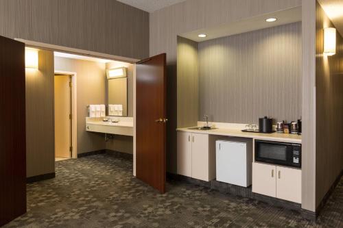 a large bathroom with a sink and a microwave at Courtyard Kansas City East/Blue Springs in Blue Springs