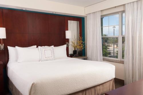 Residence Inn Fort Myers Sanibel في Truckland: غرفة نوم بسرير كبير ونافذة