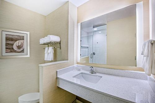 ein Badezimmer mit einem Waschbecken, einem Spiegel und einem WC in der Unterkunft Fairfield Inn & Suites by Marriott Van in Van