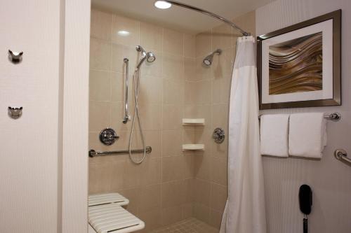 baño con ducha con cortina blanca en Courtyard by Marriott Hamilton en Hamilton