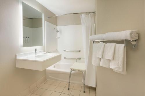 Baño blanco con lavabo y aseo en SpringHill Suites by Marriott Newark International Airport, en Newark