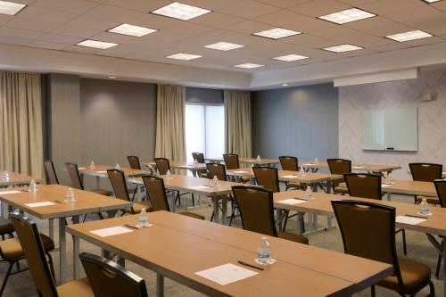 una sala conferenze con tavoli, sedie e uno schermo di SpringHill Suites by Marriott Newark International Airport a Newark