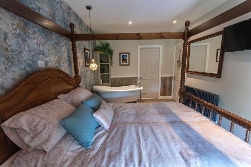 una camera con un grande letto e una vasca da bagno di Luxury retreat in Lincolnshire with hot tub a Cranwell