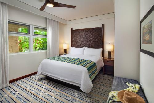 a bedroom with a large bed and two windows at Marriott's Kauai Lagoons - Kalanipu'u in Lihue