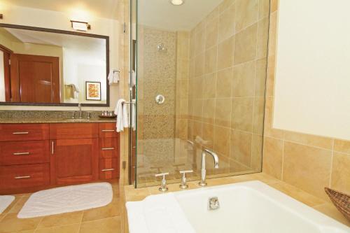 a bathroom with a tub and a sink and a mirror at Marriott's Kauai Lagoons - Kalanipu'u in Lihue