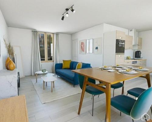 un salon avec une table et un canapé bleu dans l'établissement ArtSmalt *Idéal Pro * Proche commerces * 2 chambres * Tout confort, à Montluçon