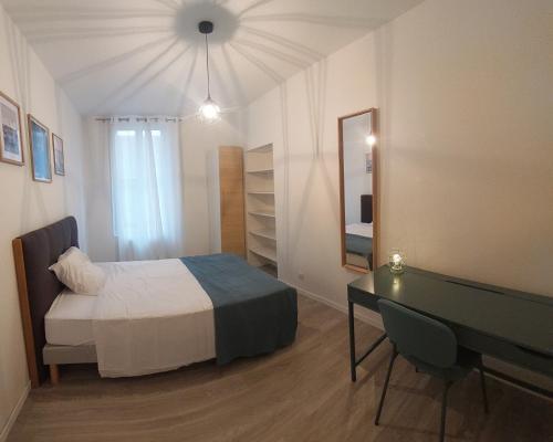 - une chambre avec un lit, un bureau et un miroir dans l'établissement ArtSmalt *Idéal Pro * Proche commerces * 2 chambres * Tout confort, à Montluçon