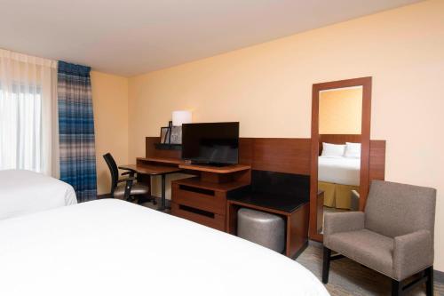 um quarto de hotel com uma cama e uma secretária com uma televisão em Fairfield Inn & Suites by Marriott Tampa Westshore/Airport em Tampa