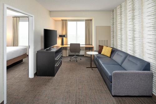 a hotel room with a couch and a bed and a desk at Residence Inn by Marriott Toronto Mississauga West in Mississauga