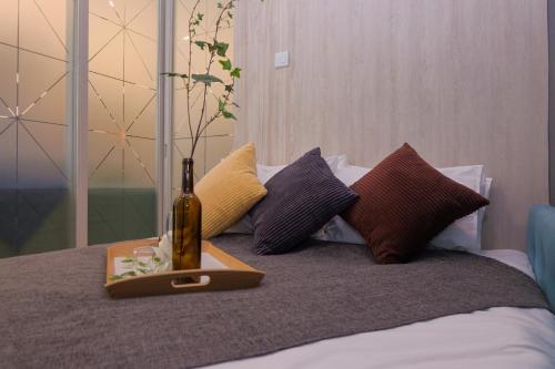 a bottle of wine sitting on a bed with pillows at 3 Bedroom Robertson at Bukit Bintang with Netflix in Kuala Lumpur