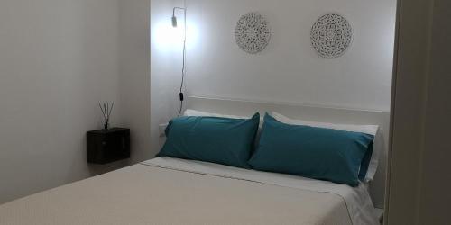 a bedroom with a bed with blue pillows on it at Casa Playita de Luz in Barbate
