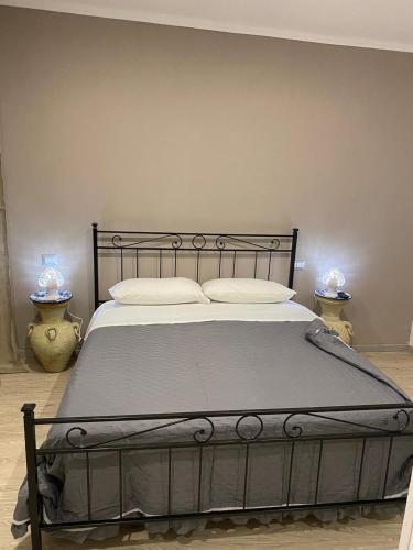 a bedroom with a large bed with a metal frame at Agriturismo Tenuta la Monaca in Aradeo