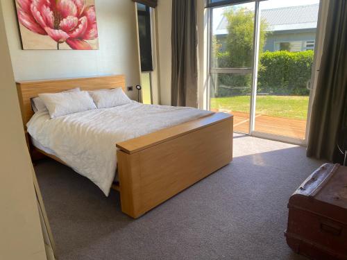 a bedroom with a bed and a large window at Luxury on Howden in Te Anau