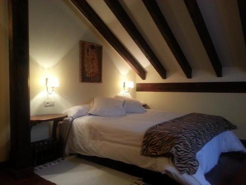 a bedroom with a bed with a zebra print blanket at Posada El Hoyal in Pesaguero-La Parte