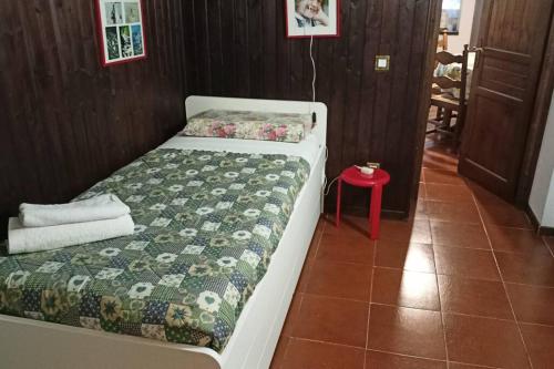 1 dormitorio con cama y mesa roja en Appartamento di montagna, en Morgex