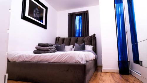 a bedroom with a large bed with blue curtains at Lovely 1-Bed Apartment in Hackney London in London
