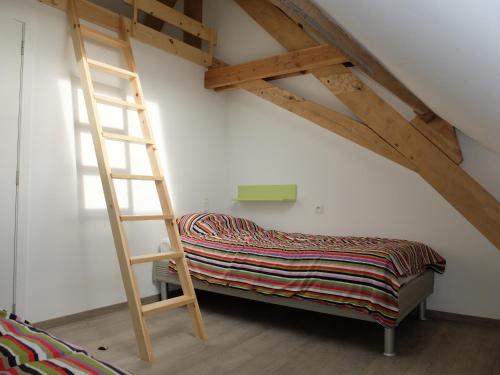 a ladder sitting next to a bed in a room at Vakantiewoning Klavertje Lier in Lier