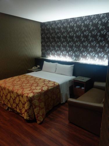 a hotel room with a bed and a couch at Klai Hotel in Kaohsiung