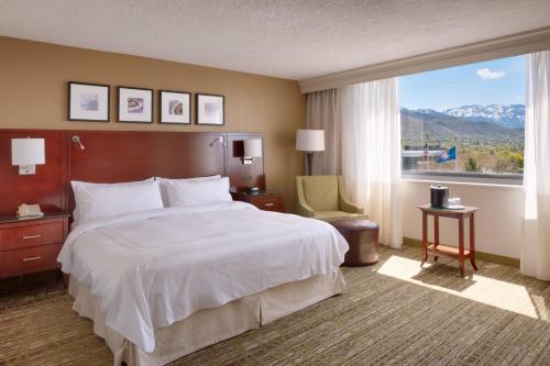 a hotel room with a bed and a large window at Salt Lake City Marriott University Park in Salt Lake City