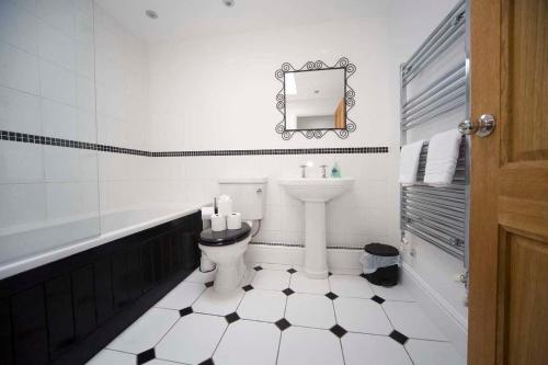 a bathroom with a toilet and a sink and a mirror at Wolviston Cottage in Wolviston