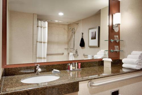 uma casa de banho com um lavatório e um espelho grande em Salt Lake City Marriott University Park em Salt Lake City