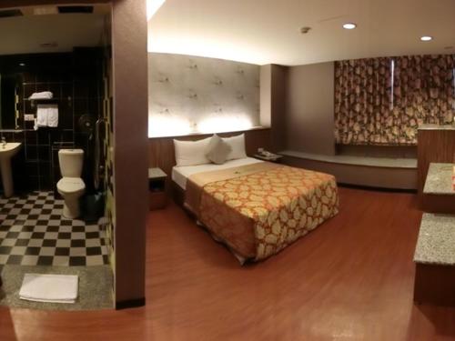 a hotel room with a bed and a bathroom at Klai Hotel in Kaohsiung