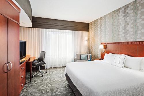 a hotel room with a bed and a desk at Courtyard by Marriott Knoxville Airport Alcoa in Alcoa